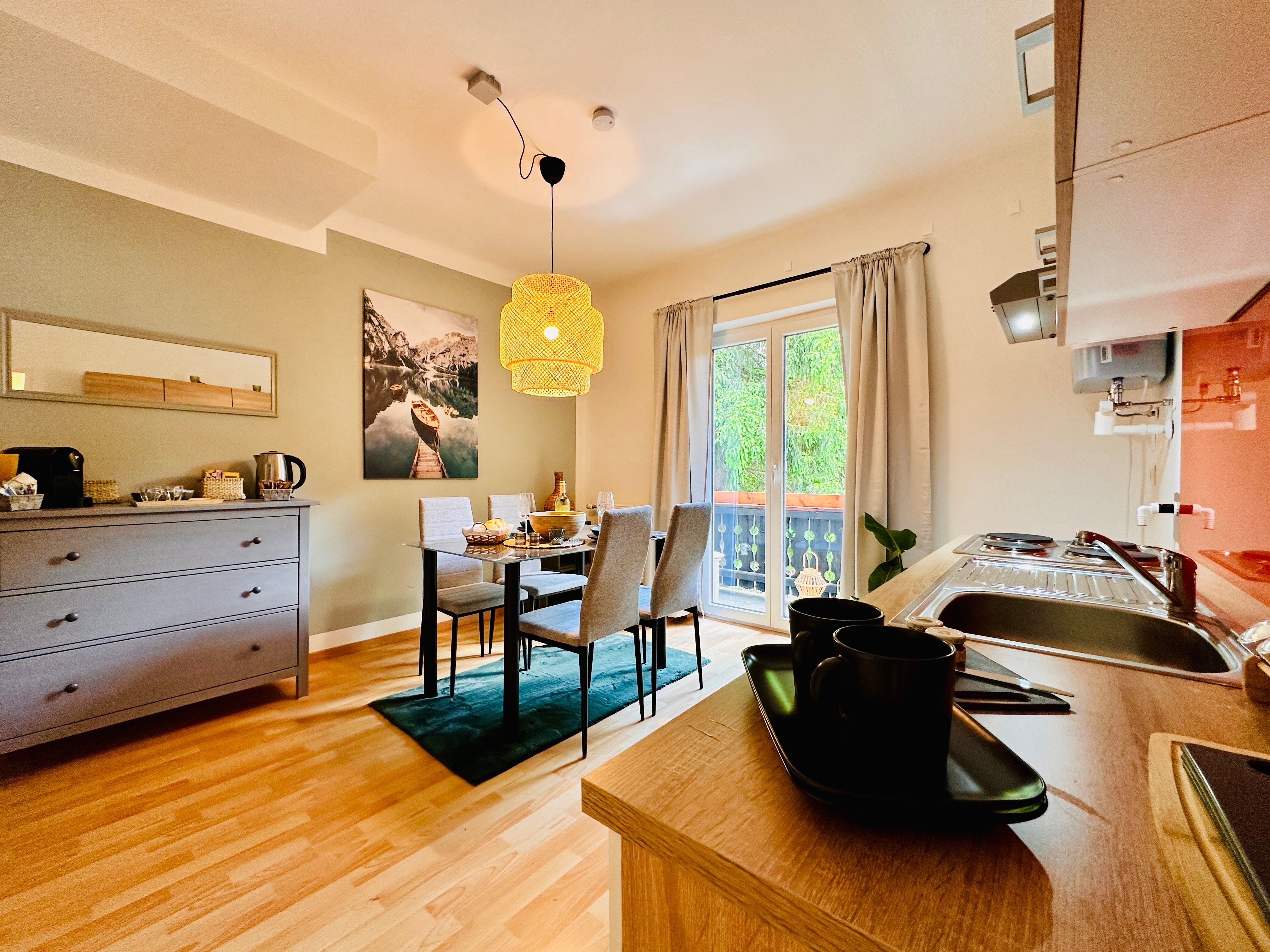 Útulný byt s jedálenským stolom, kuchynským kútom a balkónom.