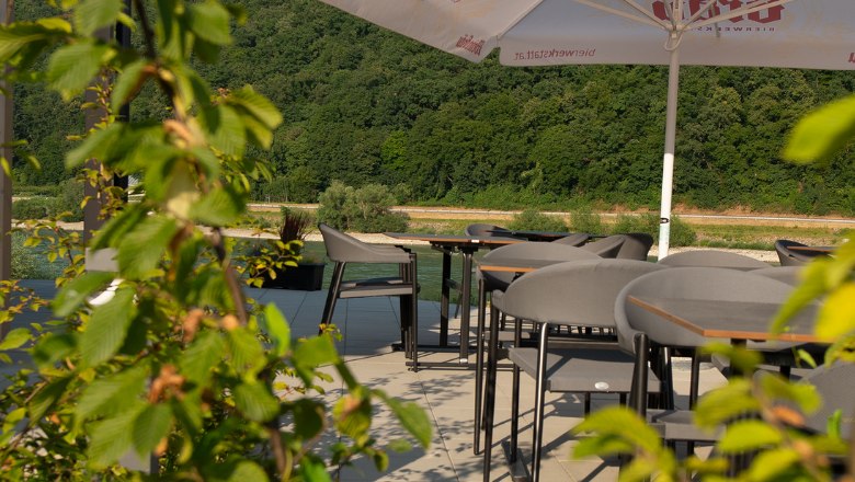 Stoly na terase so zelen&yacute;mi rastlinami