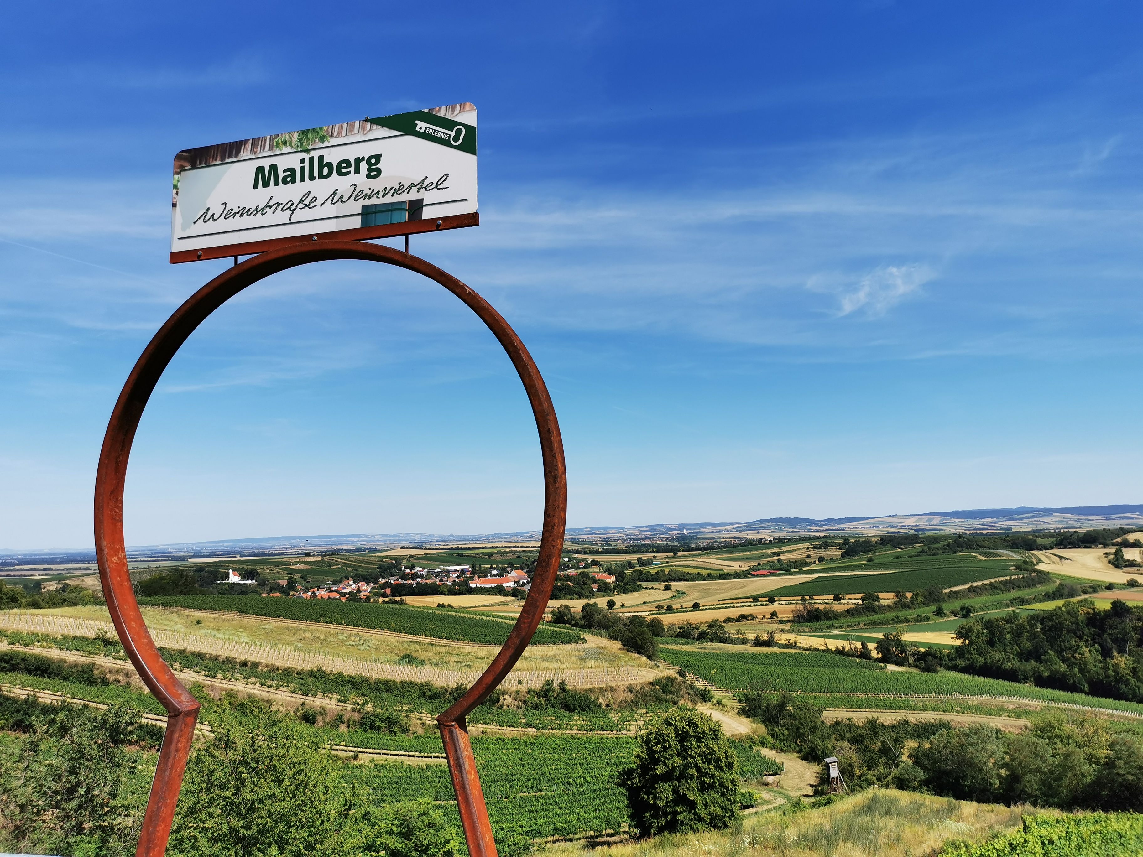 Krajina s vinicami a nápisom "Mailberg Vínna cesta Weinviertel".