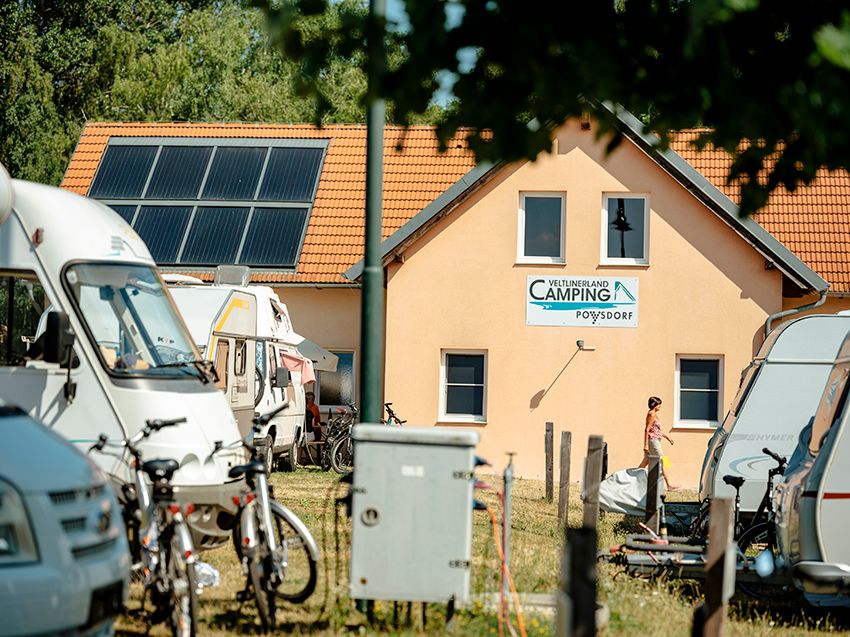 Kemp s mobilnými domčekmi a sanitárnou budovou v pozadí.