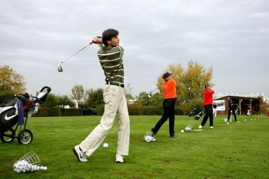 Ľudia hrajúci golf na golfovom ihrisku.