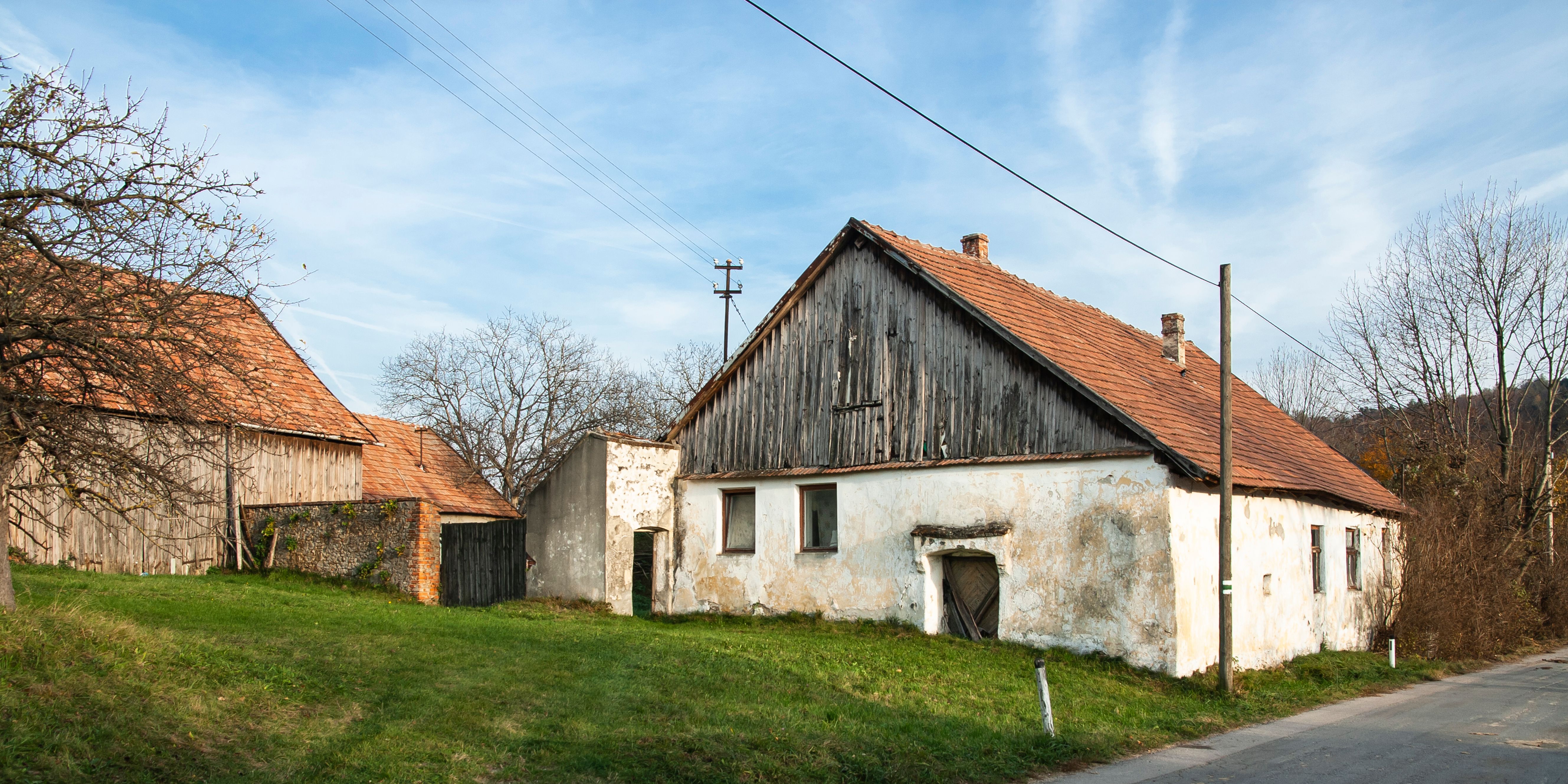 Staré budovy v Vínných uličkách Sieghartskirchen s červenými škridlovými strechami a zvetranými fasádami.