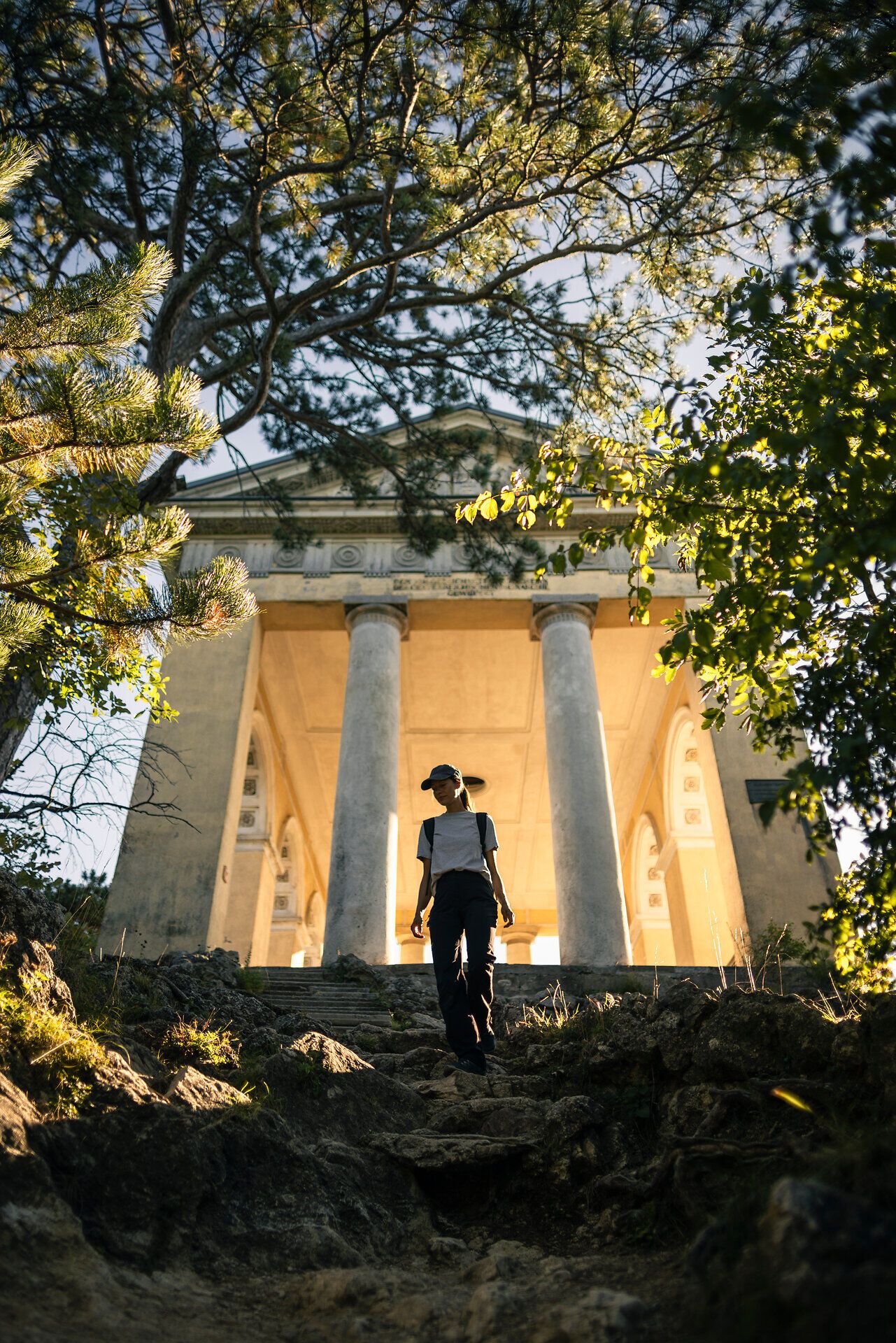 Frau wandert bergab, Husarentempel im Hintergrund