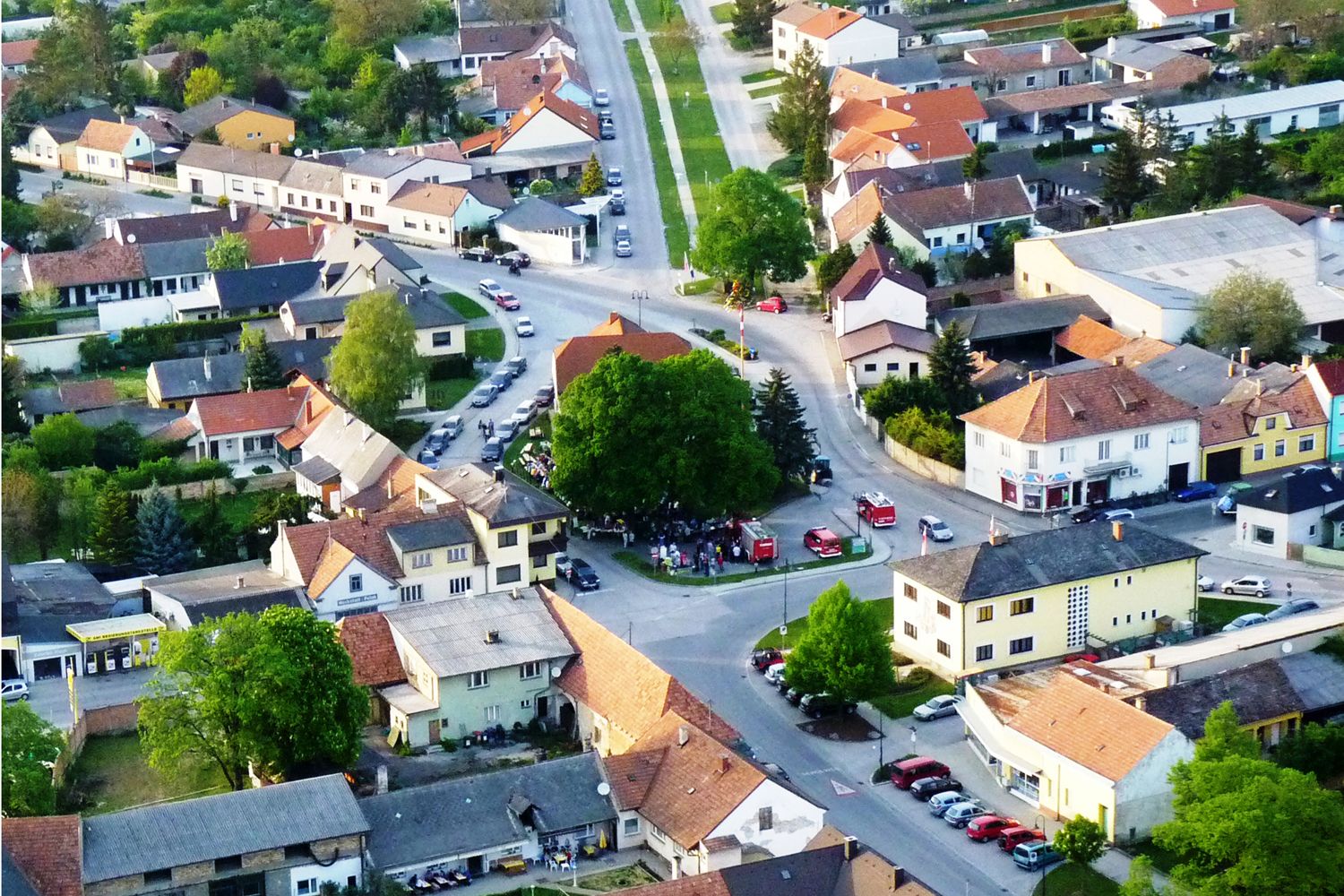 Letecký pohľad na malé mesto s domami, ulicami a stromami.
