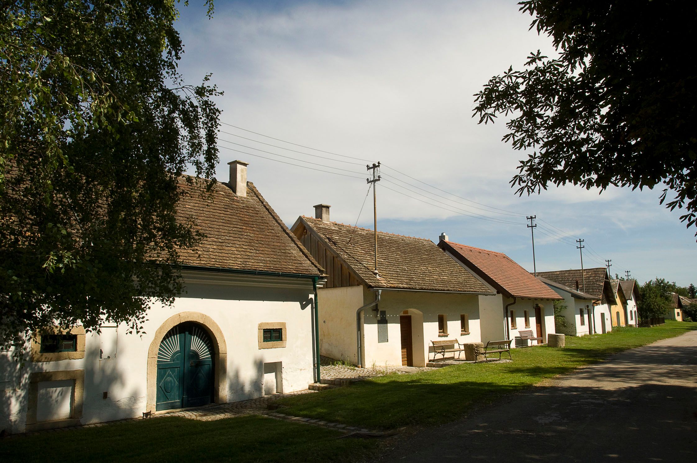 Rad vínnych pivníc v rakúskom Schöngraberne za slnečného počasia.