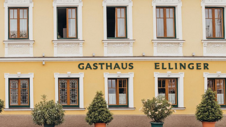 Fasáda žltého hostinca s nápisom "Gasthaus Ellinger".