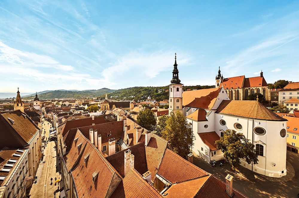 Panoramatický pohľad na staré centrum mesta Krems s kostolmi a červenými strechami.