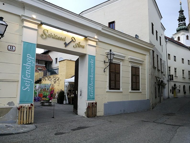 Vchod do kancelárie s kľúčmi a nápismi pre obchod s mydlom a trh so suvenírmi.