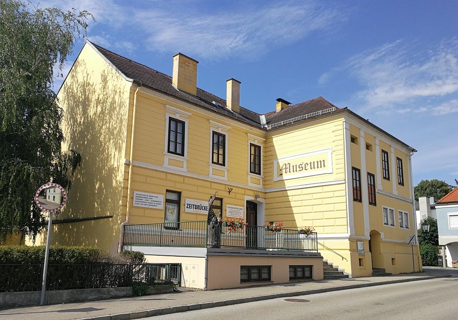 Žltá budova označená "Museum" a "Zeitbrücke".
