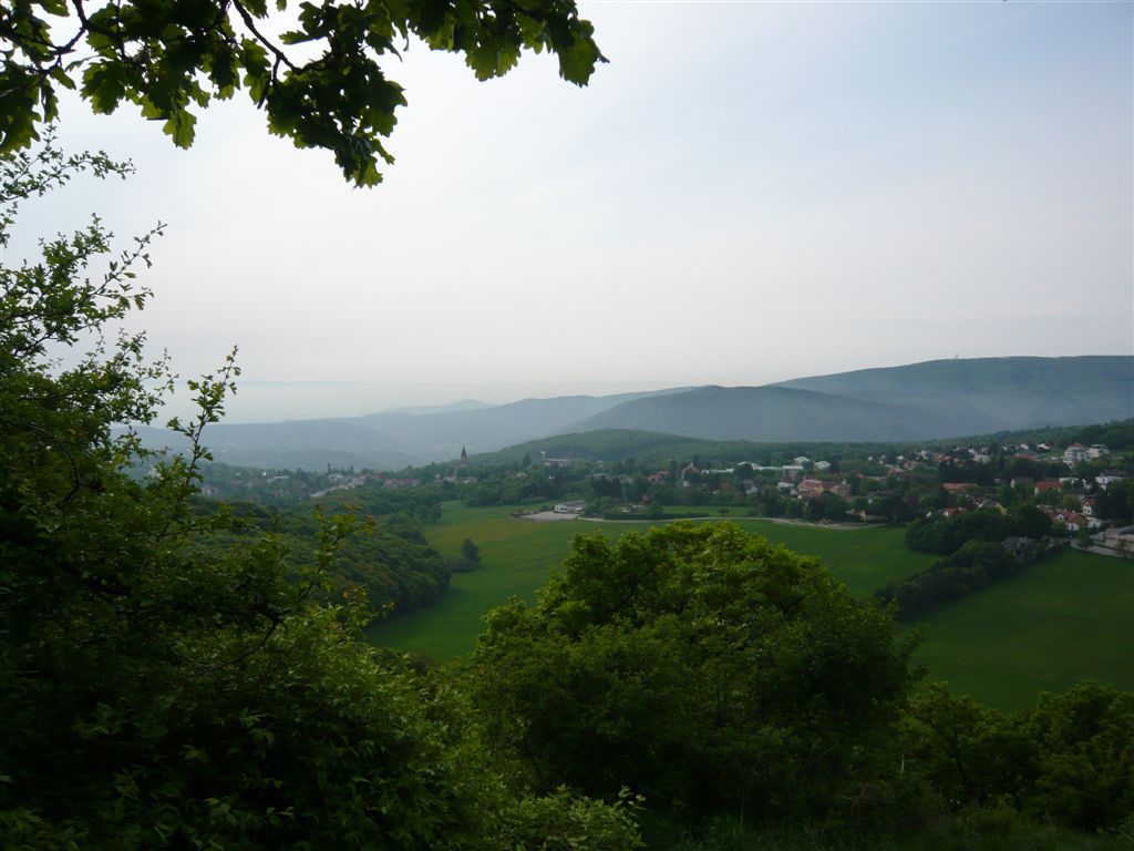 Pohľad na Gießhübl so zelenými kopcami a stromami v popredí.