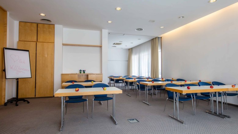 Semin&aacute;rna miestnosť so stolmi, stoličkami a jablkami na stoloch.