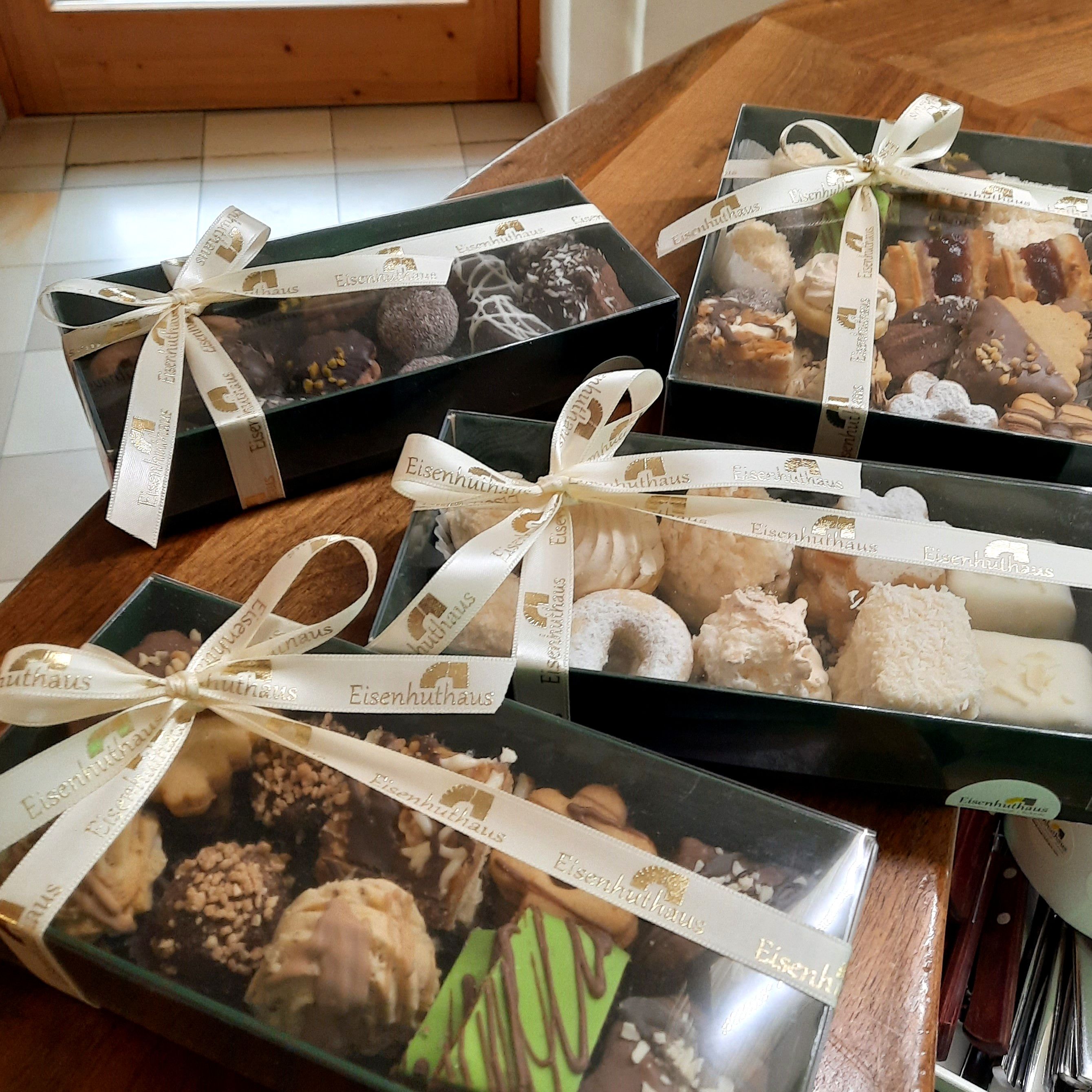 Darčekové krabice s vianočnými sušienkami na stole.