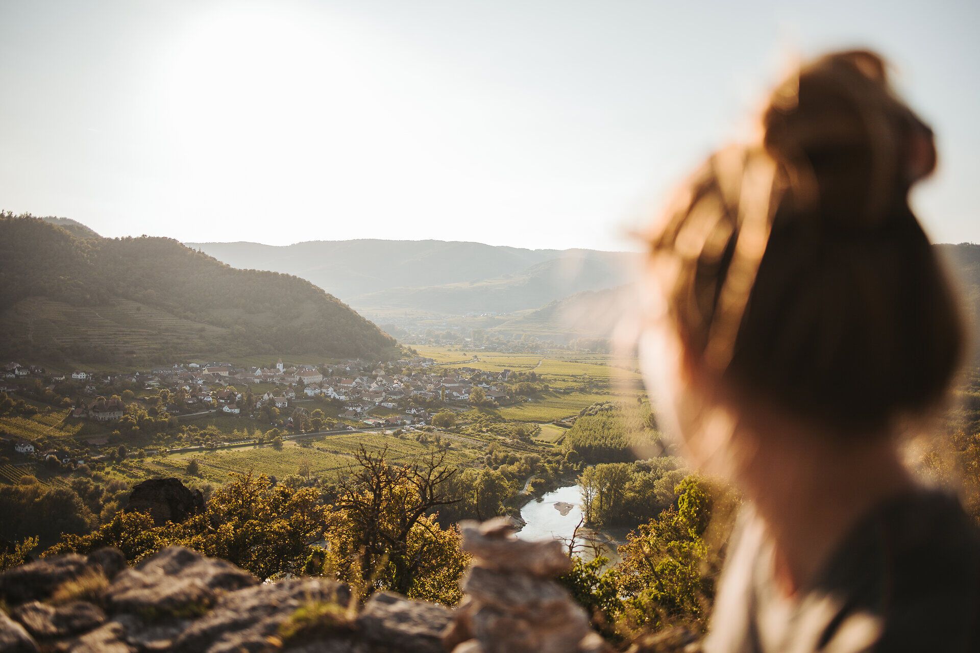 Die sanften Hügel der Wachau erstrecken sich majestätisch im goldenen Licht der Abendsonne. Ein ruhiger Fluss schlängelt sich durch die Landschaft, während die charmanten Dörfer in der Ferne einladend wirken. Hier, wo Natur und Kultur harmonisch verschmelzen, wird jeder Schritt zu einem unvergesslichen Erlebnis.