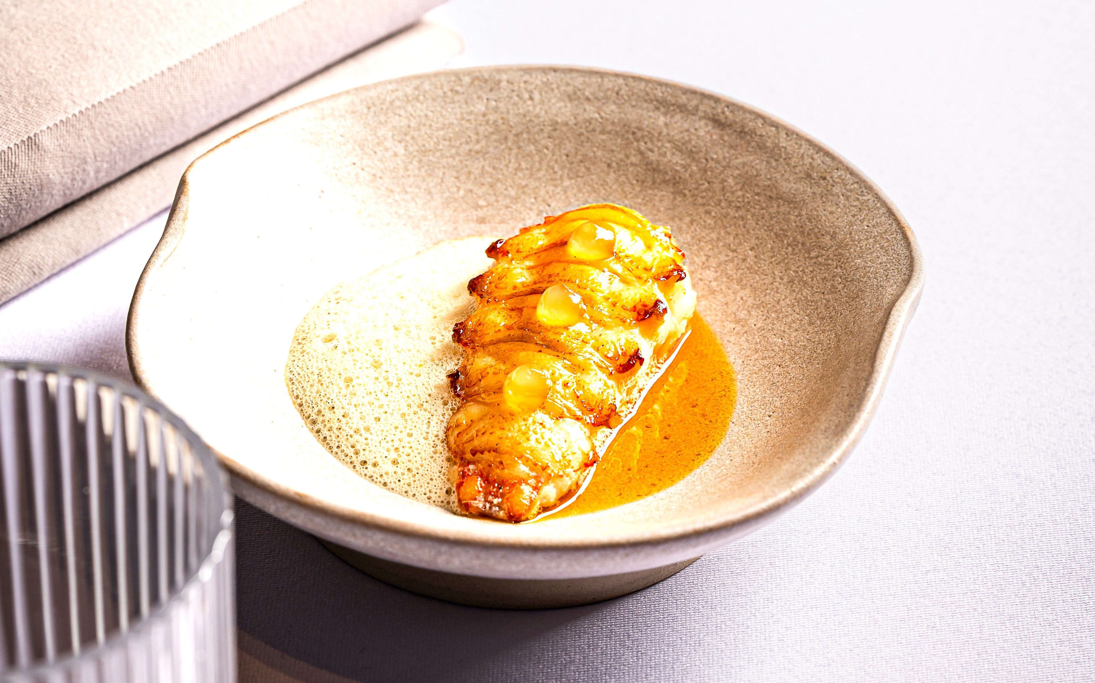 Umne pripravený pokrm v miske s penou a omáčkou.