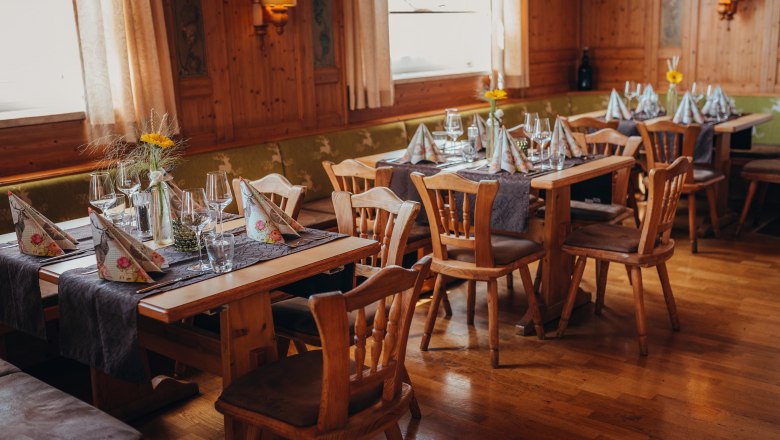 Útulná reštaurácia s dreveným nábytkom a prestretými stolmi.