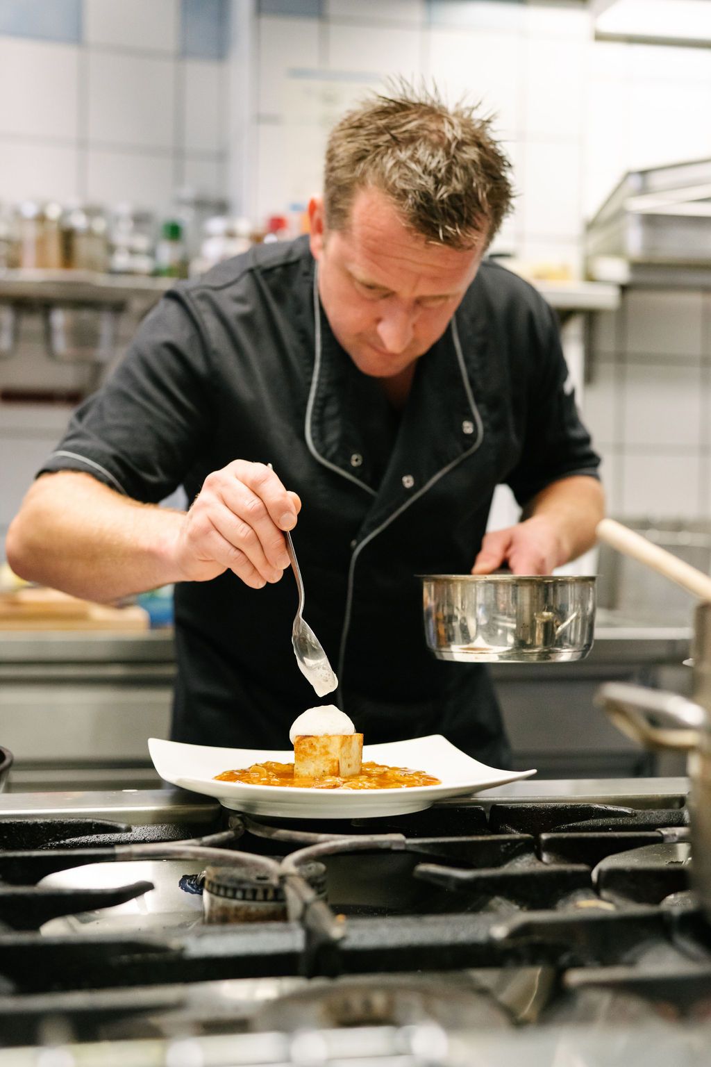 Šéfkuchár zdobí pokrm v profesionálnej kuchyni.