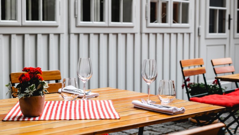 Dreven&yacute; st&ocirc;l vonku s kvetmi a poh&aacute;rmi.