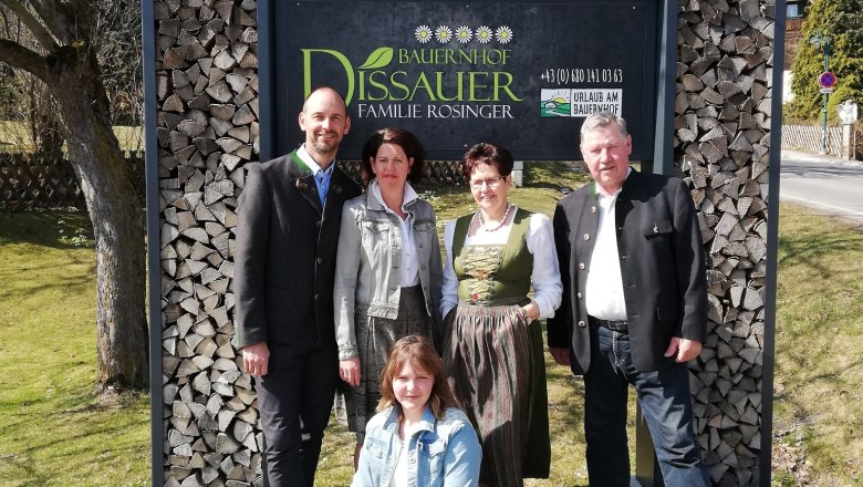 Päť ľudí pred tabuľou s nápisom "Bauernhof Dissauer Familie Rosinger".