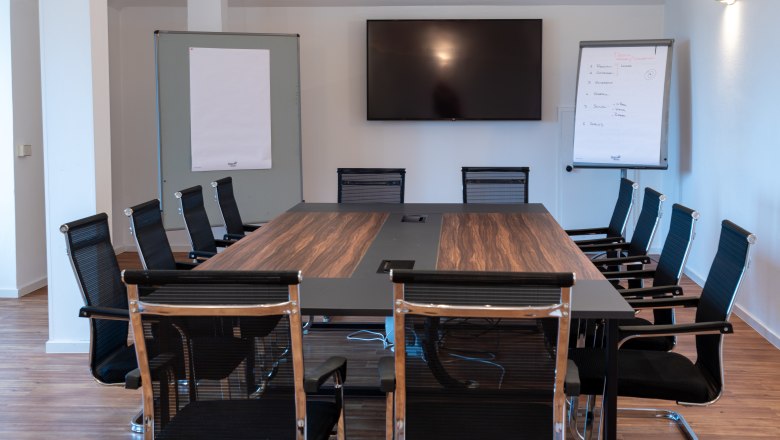 Semin&aacute;rna miestnosť so stolom, stoličkami a obrazovkou