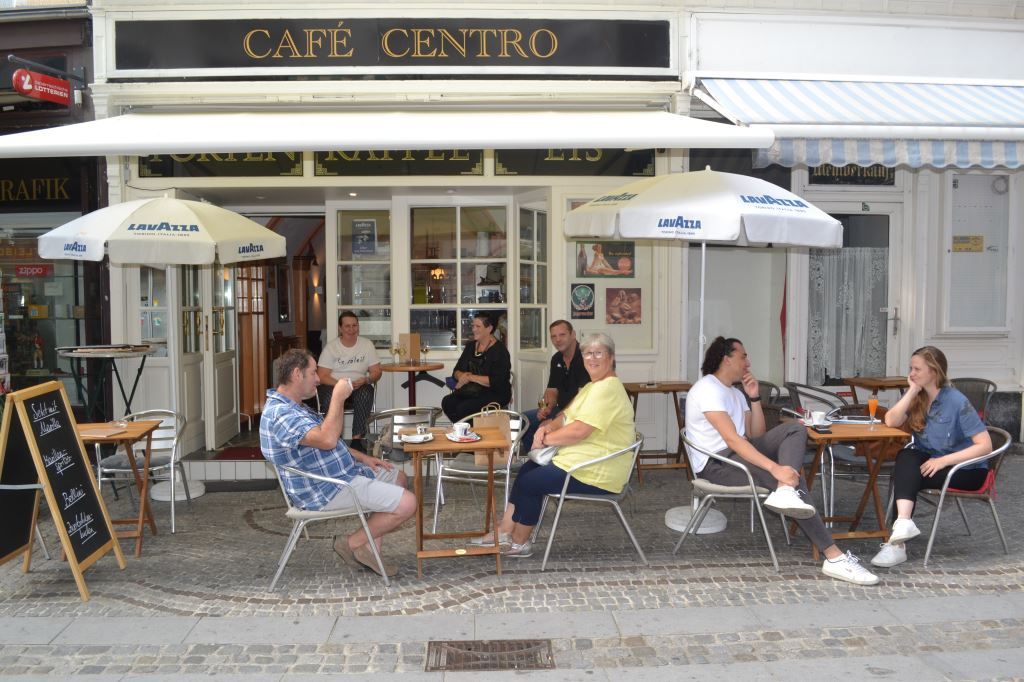 Ľudia sedia pred kaviarňou Café Centro.