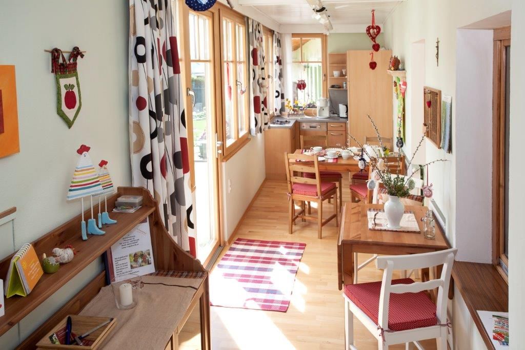 Útulný prázdninový byt s dreveným nábytkom, jedálenským stolom a ozdobnými závesmi.