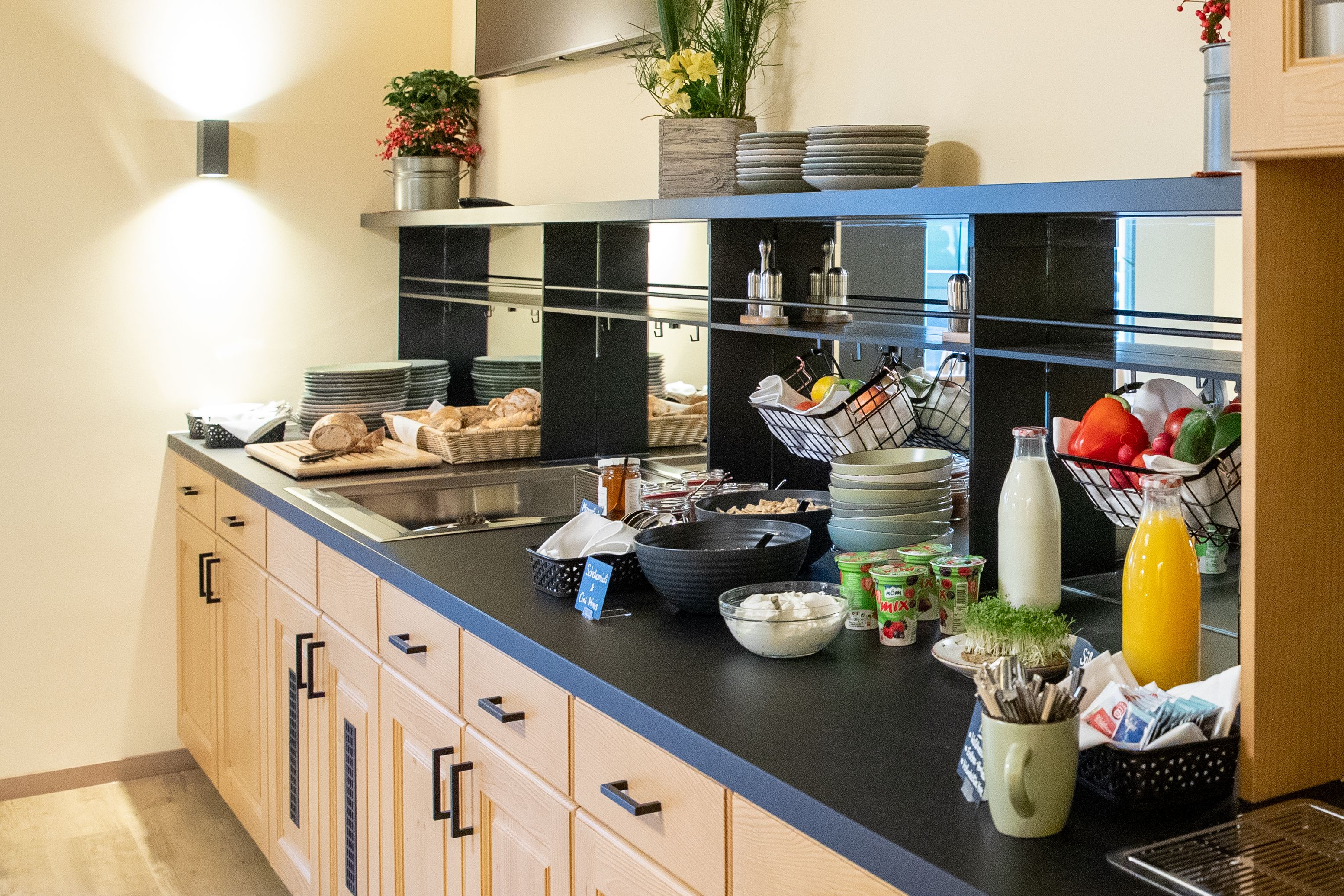 Raňajkový bufet s chlebom, jogurtom, džúsom a zeleninou.