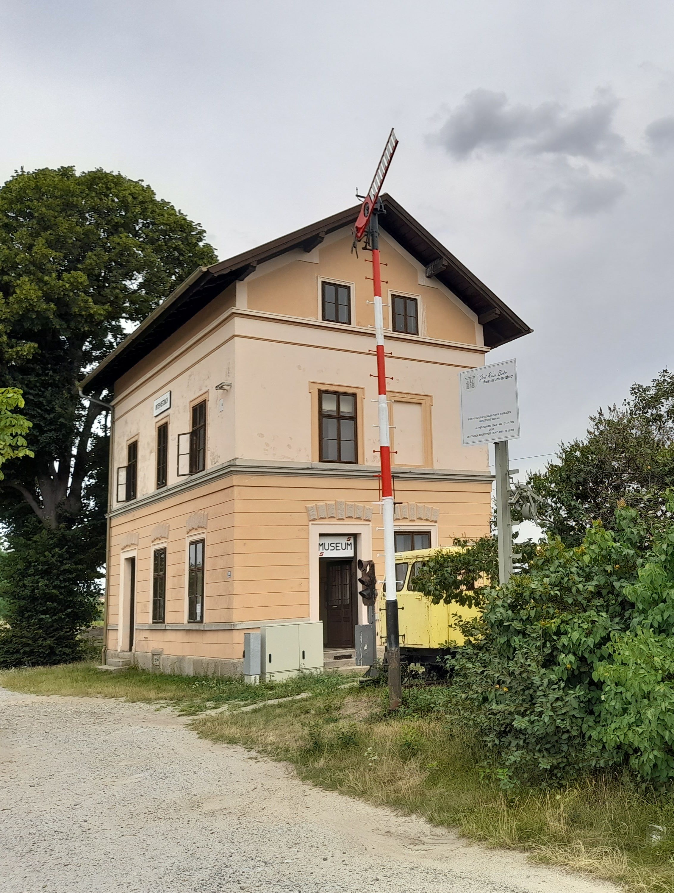 Budova starej železničnej stanice s múzejnou tabuľou a návestidlom v Unter-Retzbachu.