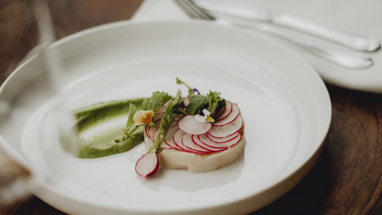 Jedlo s uhorkami, reďkovkami a wasabi krémom, zdobené jedlými kvetmi.