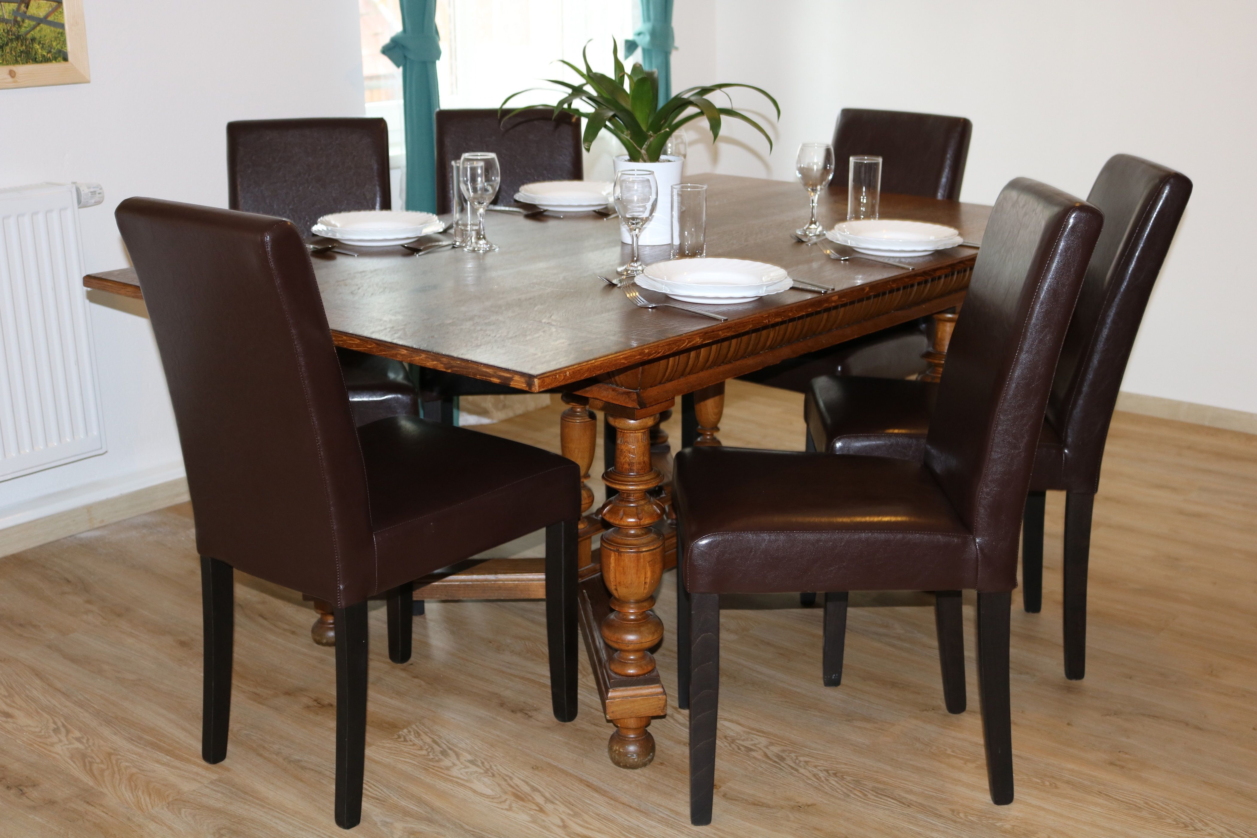 Jedálenský kút s dreveným stolom a šiestimi hnedými stoličkami pre šesť osôb.