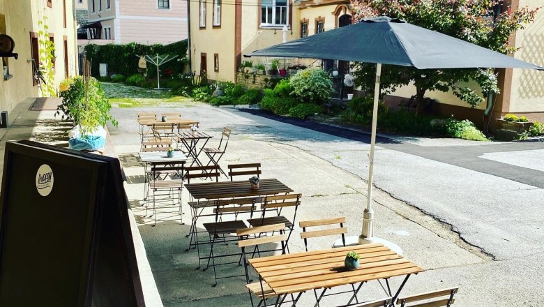 Z&aacute;hrada pre host&iacute; s dreven&yacute;mi stolmi a stoličkami, slnečn&iacute;kom a rastlinami vo vn&uacute;tornom dvore.