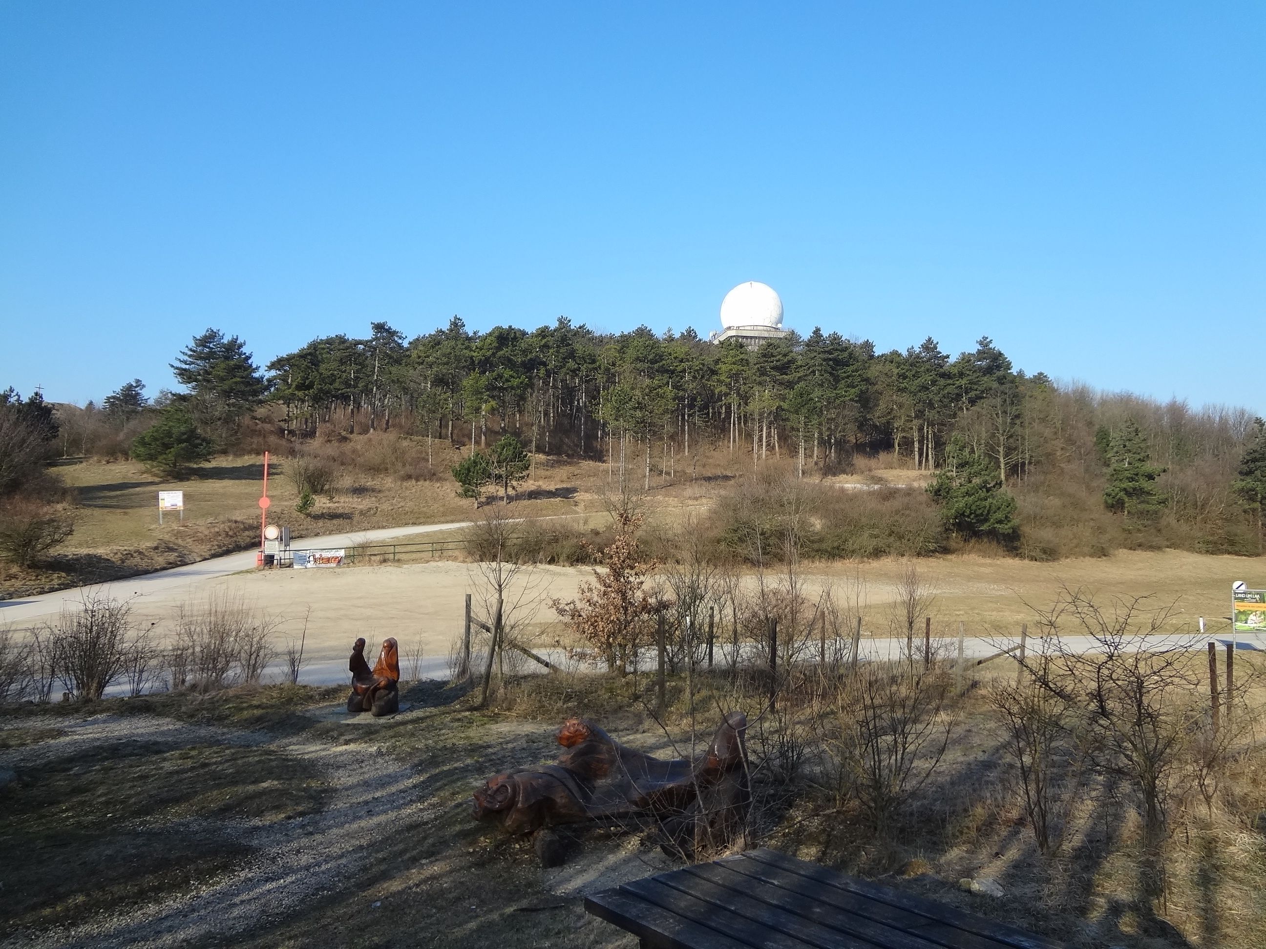 Krajina s kopcami, lesom a radarovou kupolou na vrchu Buschberg.