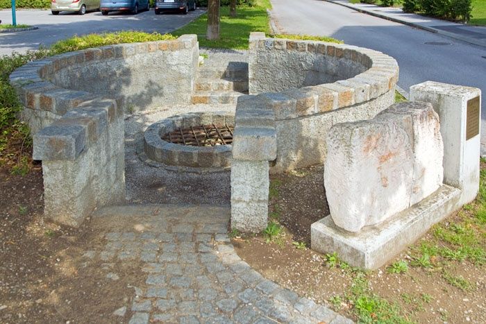 Rímska studňa v Traismauer s kamennými konštrukciami a mriežkou nad otvorom.