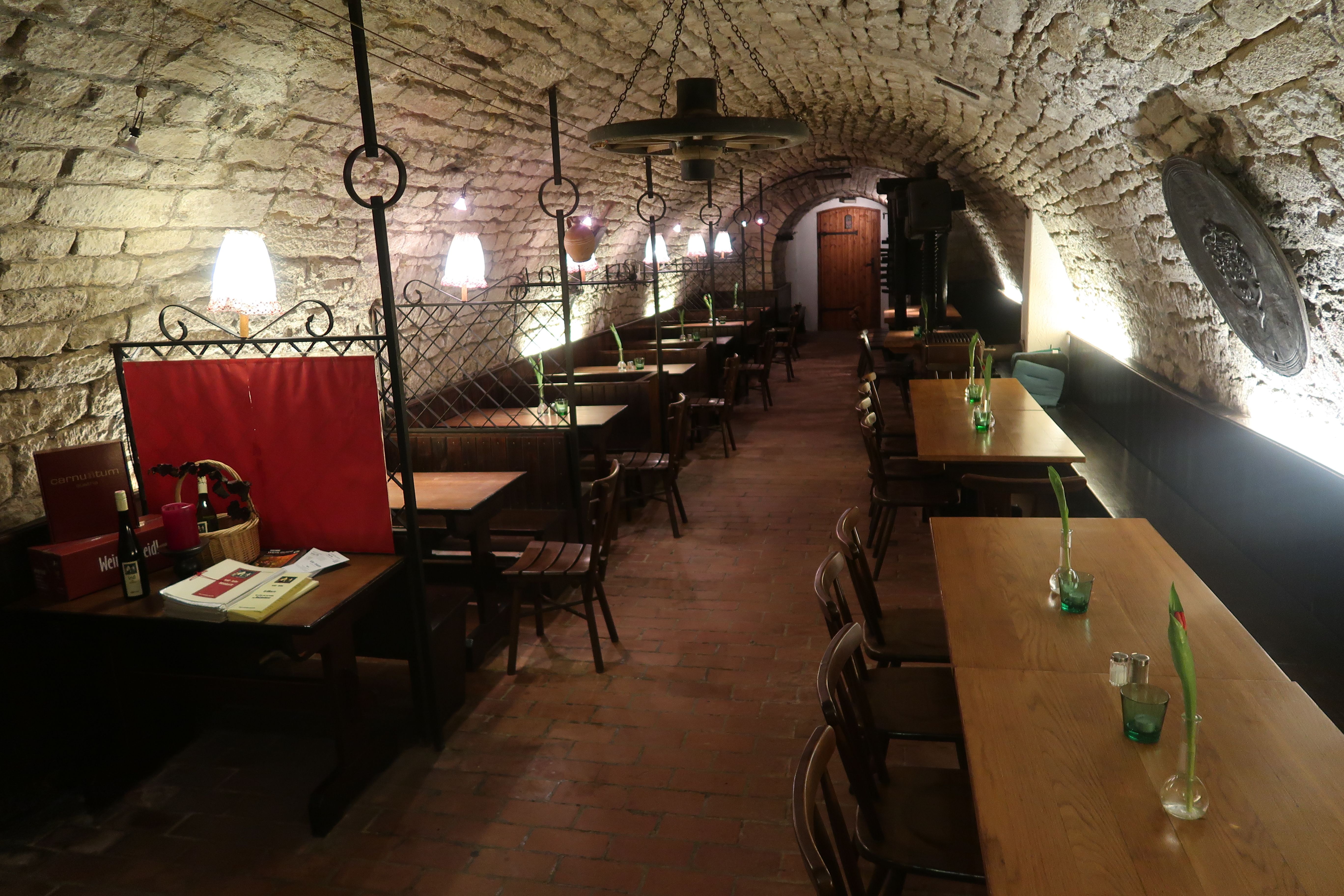 Kamenná klenutá pivnica so stolmi a kreslami 