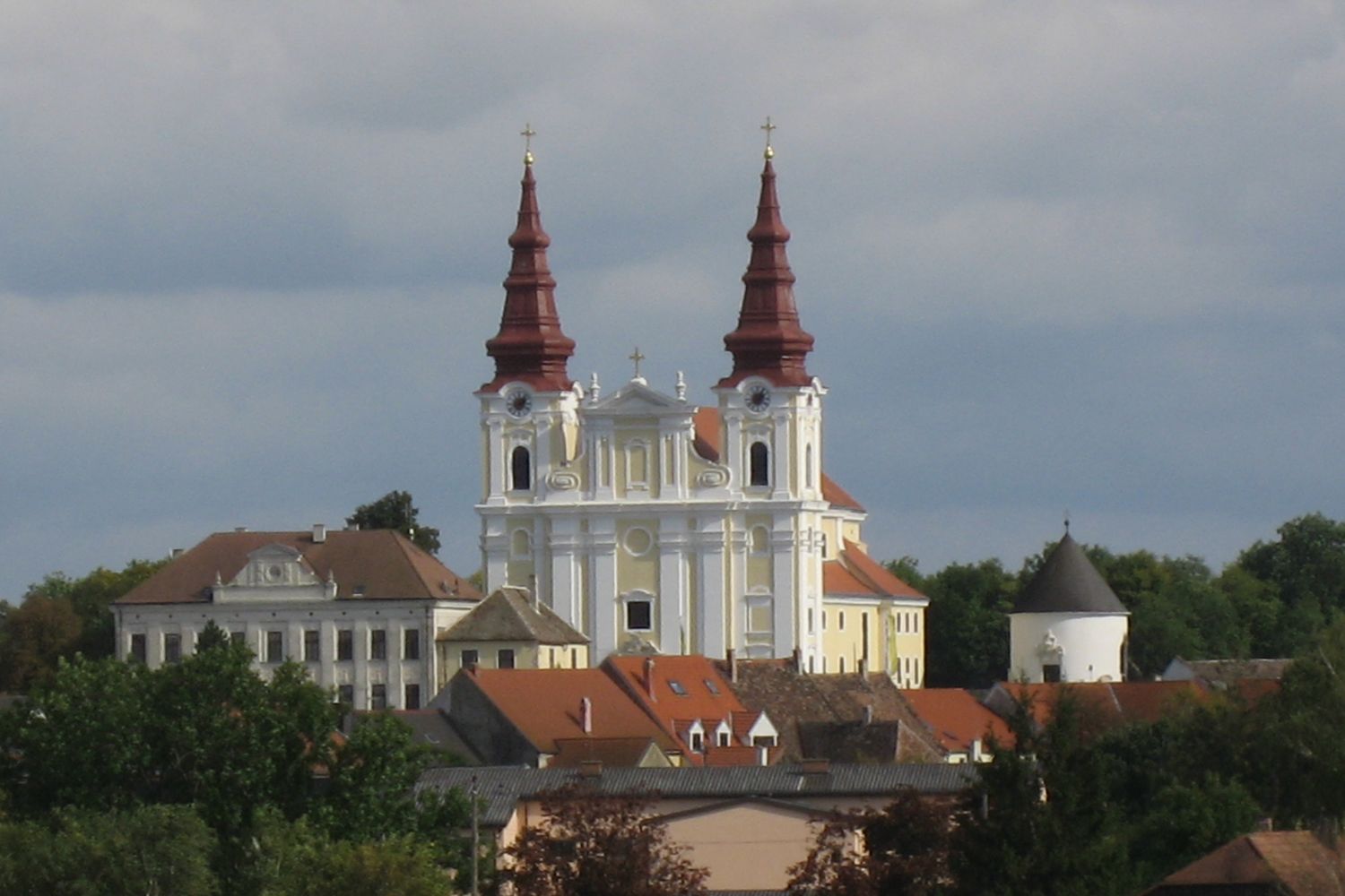 Barokový kostol s dvoma vežami a okolitými budovami.