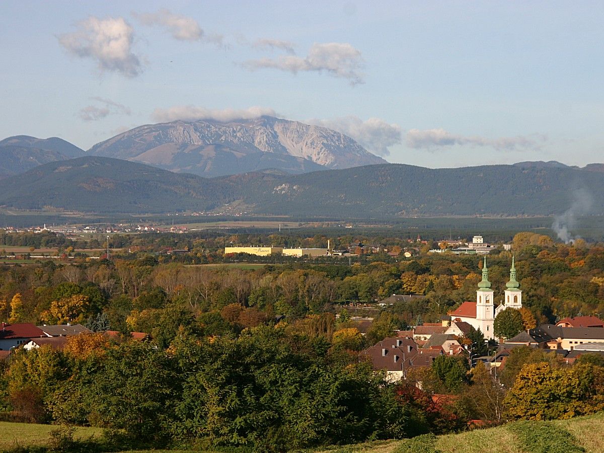 Panoráma Schwarzau am Steinfeld s kostolom a horami v pozadí.
