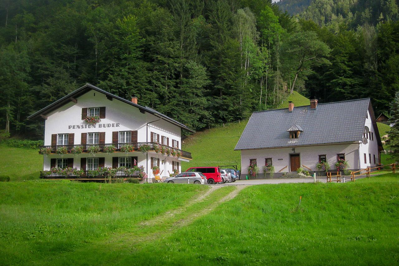 Dve tradičné budovy v zelenom zalesnenom prostredí.