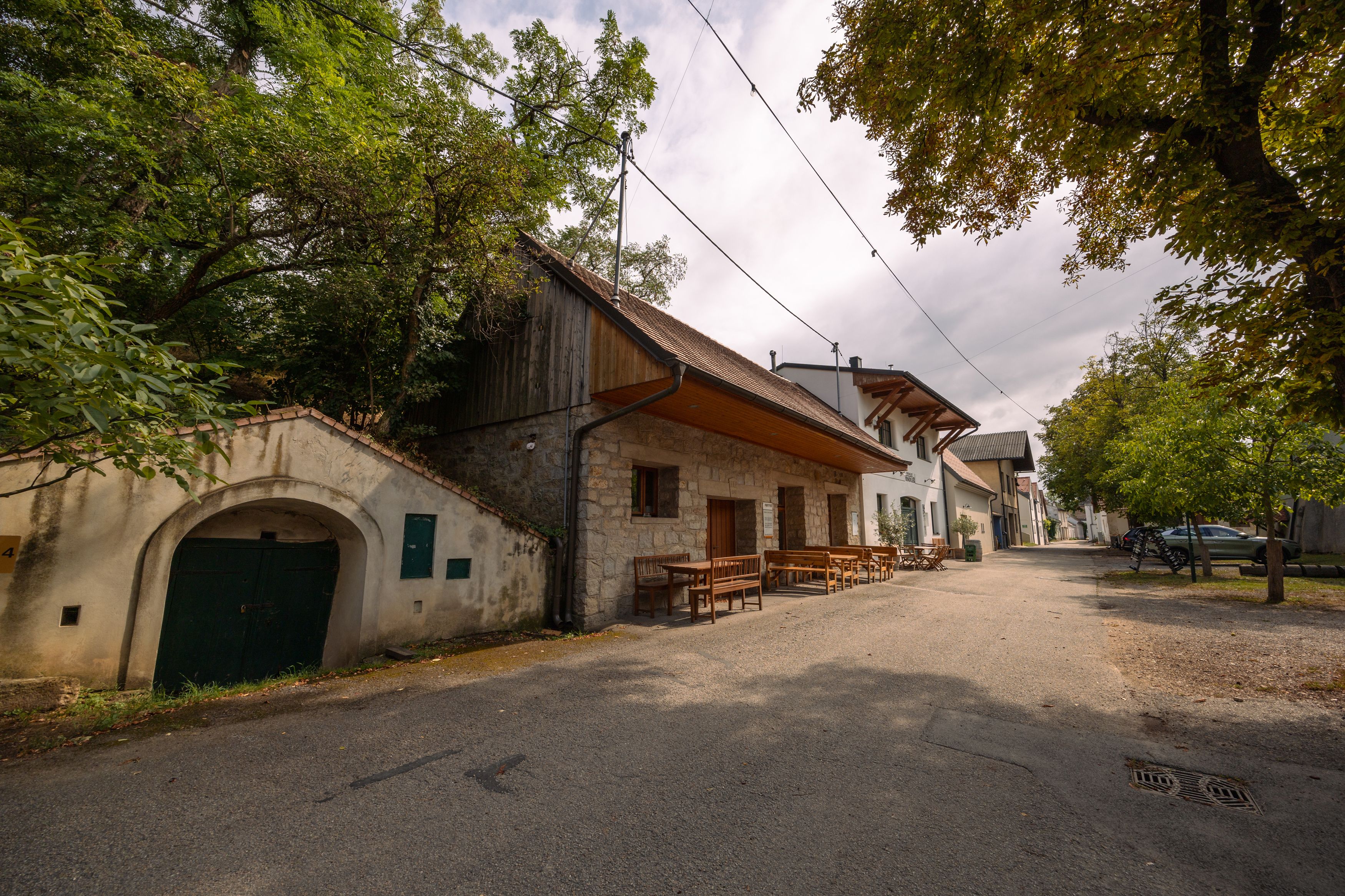 Weinviertler Kellerstöckl s rustikálnymi budovami a stromami.