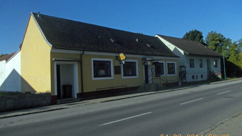 Exteri&eacute;rov&yacute; pohľad na žlt&yacute; hostinec na ulici z 24.9.2014.