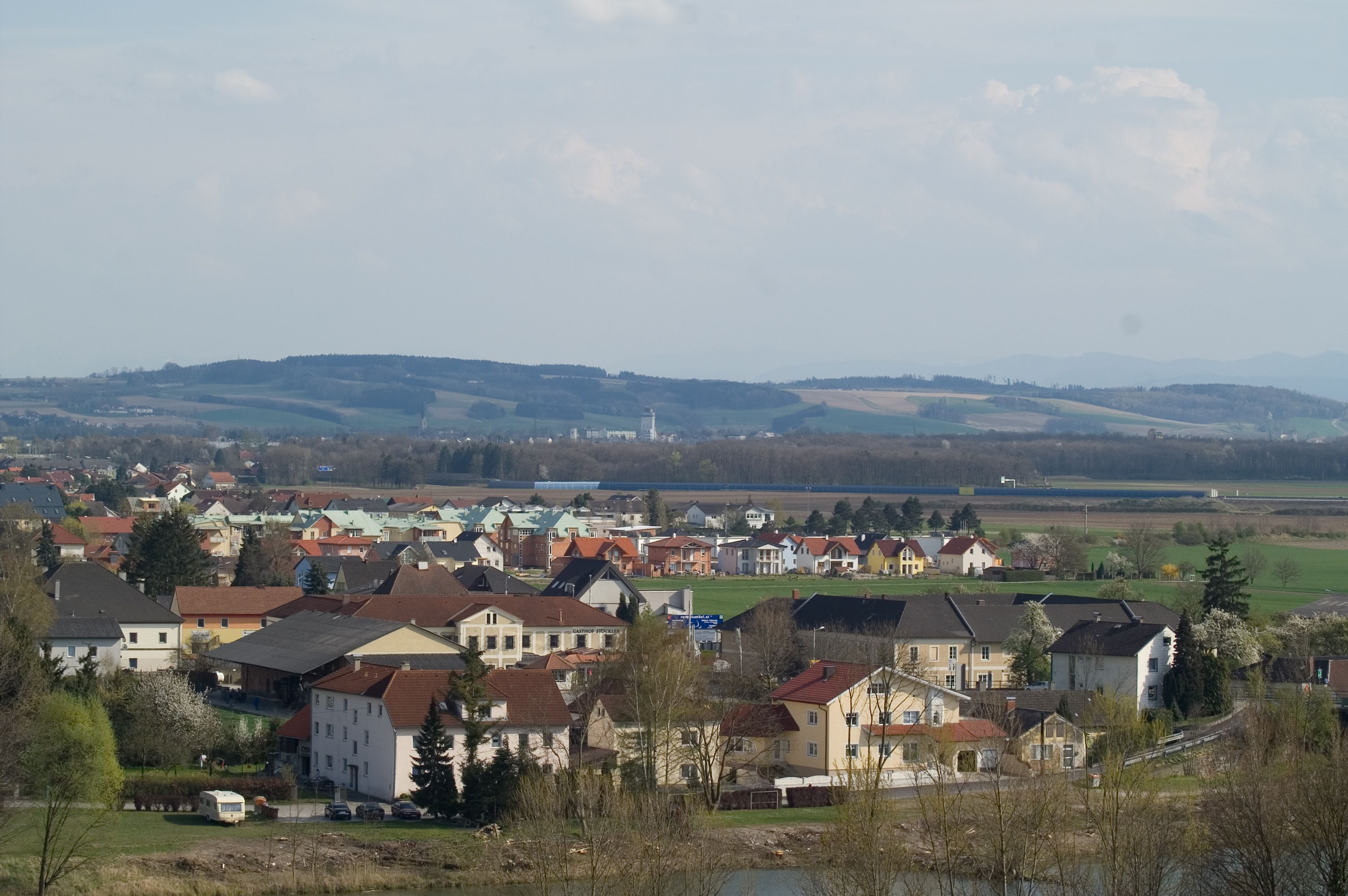 Panoramatický pohľad na Ennsdorf s domami a kopcami v pozadí.
