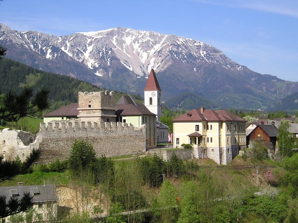Zrúcanina hradu Puchberg so zasneženou horou v pozadí.