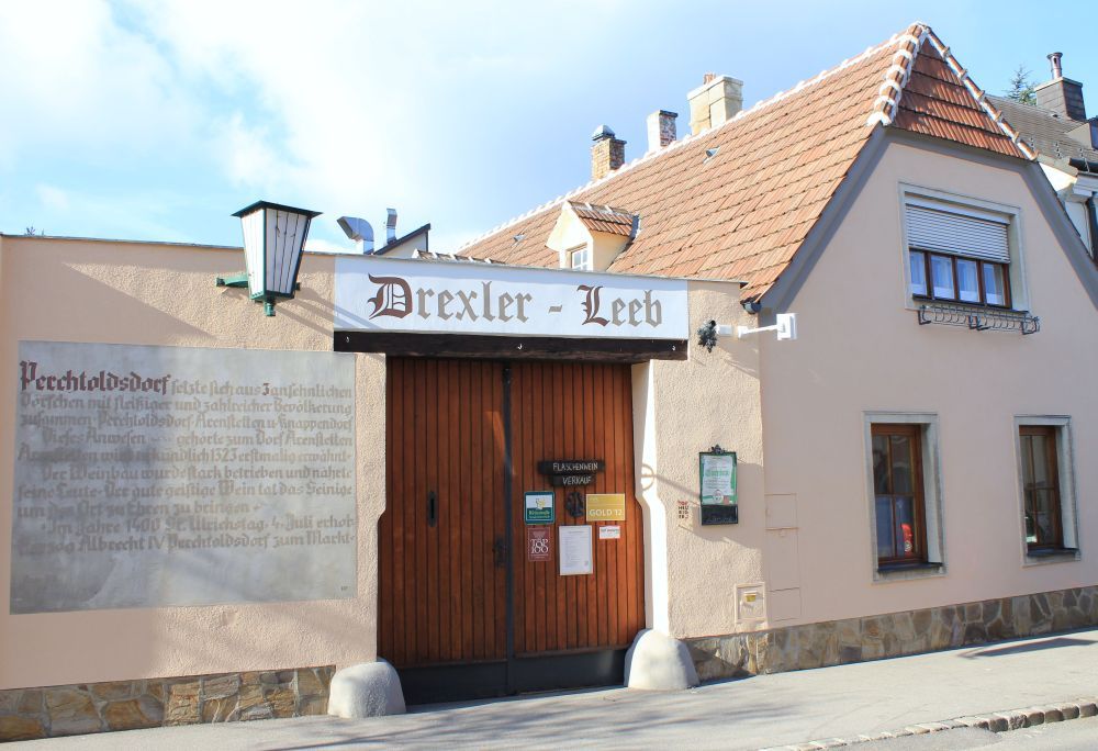Tradičná budova s nápisom "Drexler-Leeb" a drevenou bránou.