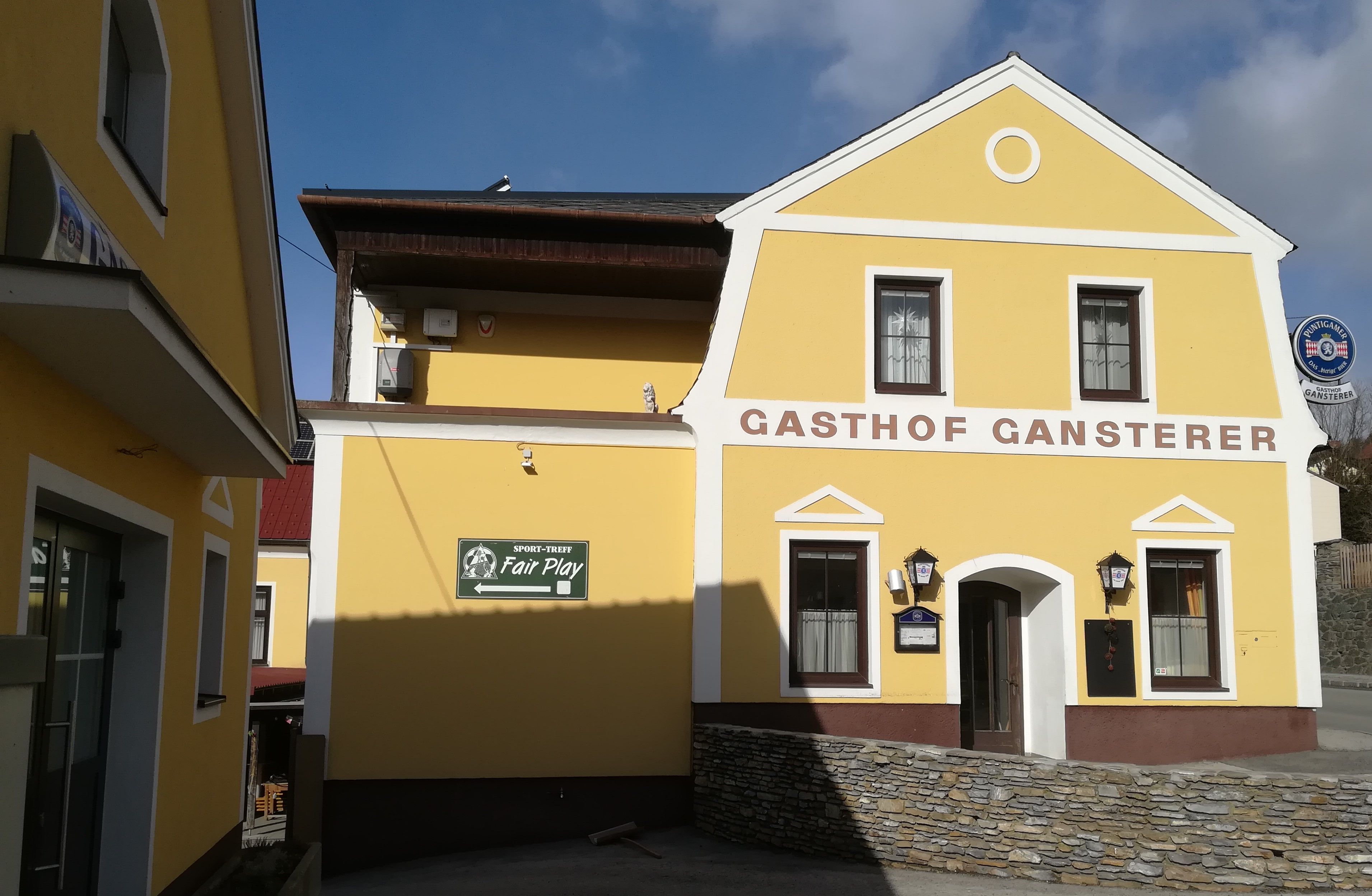 Žltá budova s nápisom "Gasthof Gansterer".