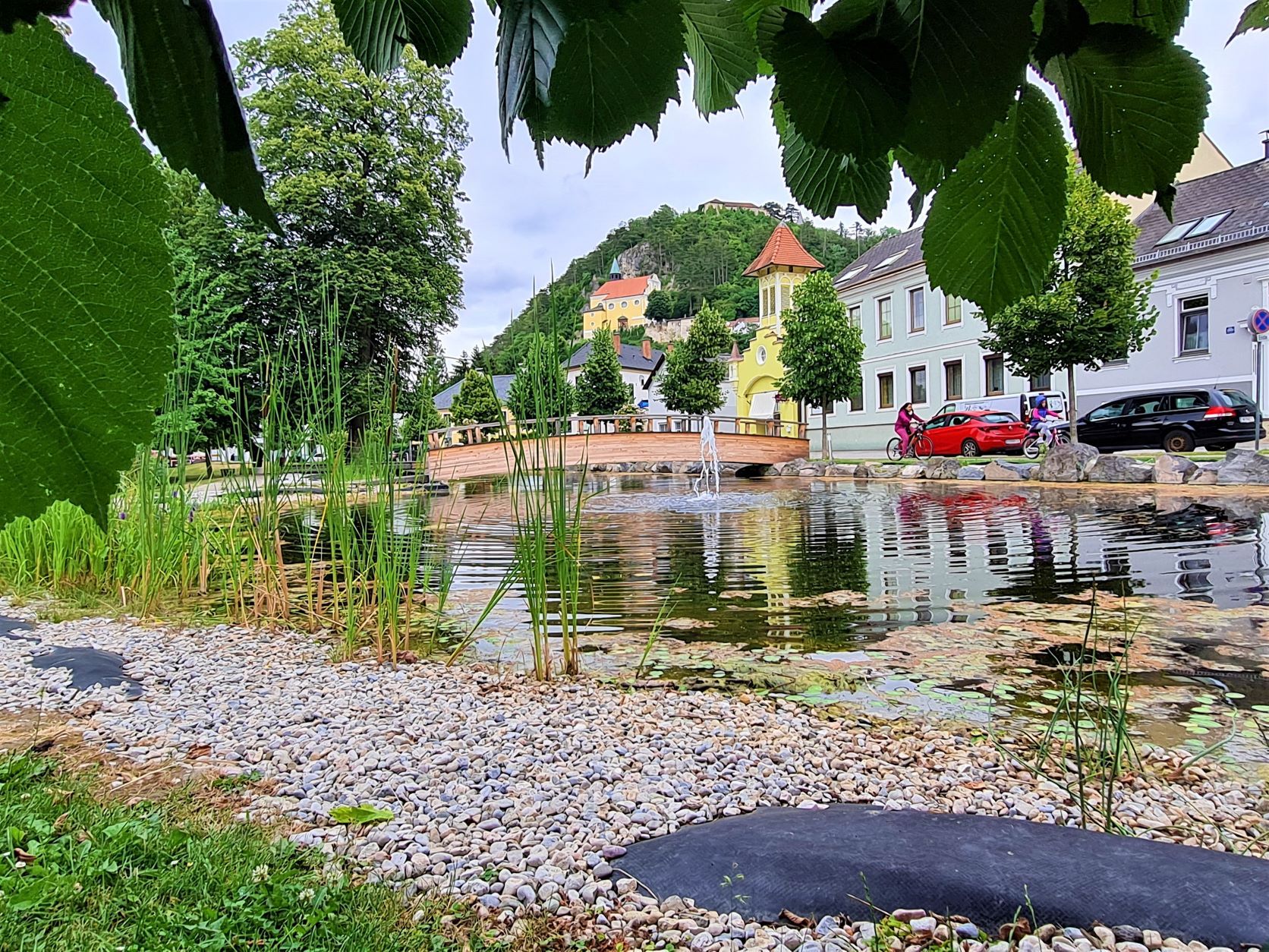 Pohľad na horský kostol Pitten z parku s rybníkom a mostom