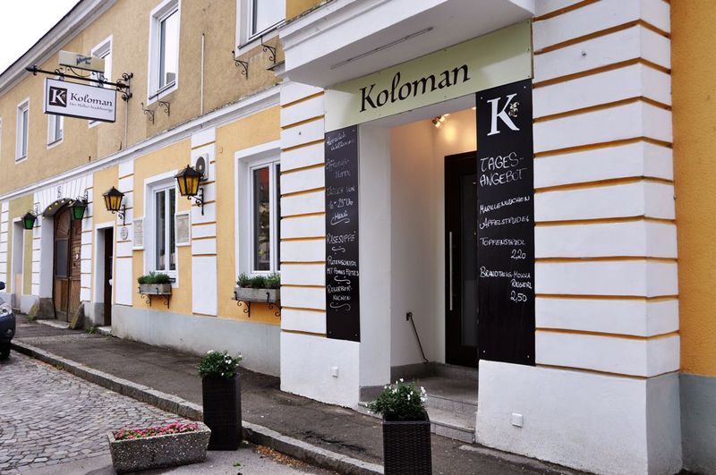 Vstup do reštaurácie Koloman v Melku s dennými ponukami na tabuliach.