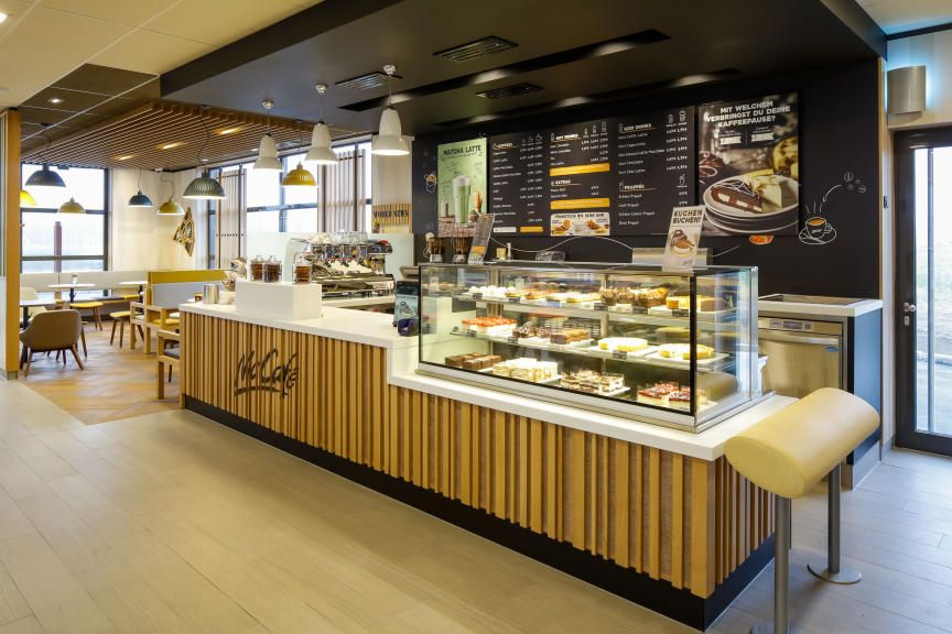 Pohľad do interiéru kaviarne McCafé s pultom a priestorom na sedenie.