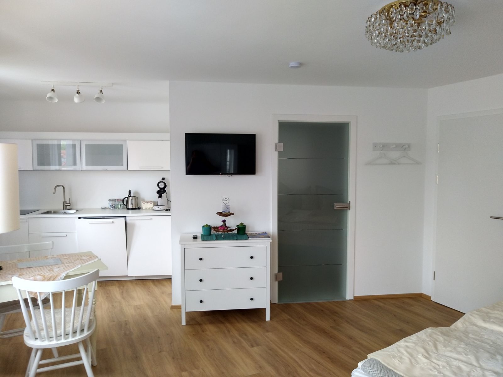 Moderný byt s kuchyňou, jedálenským stolom a TV.