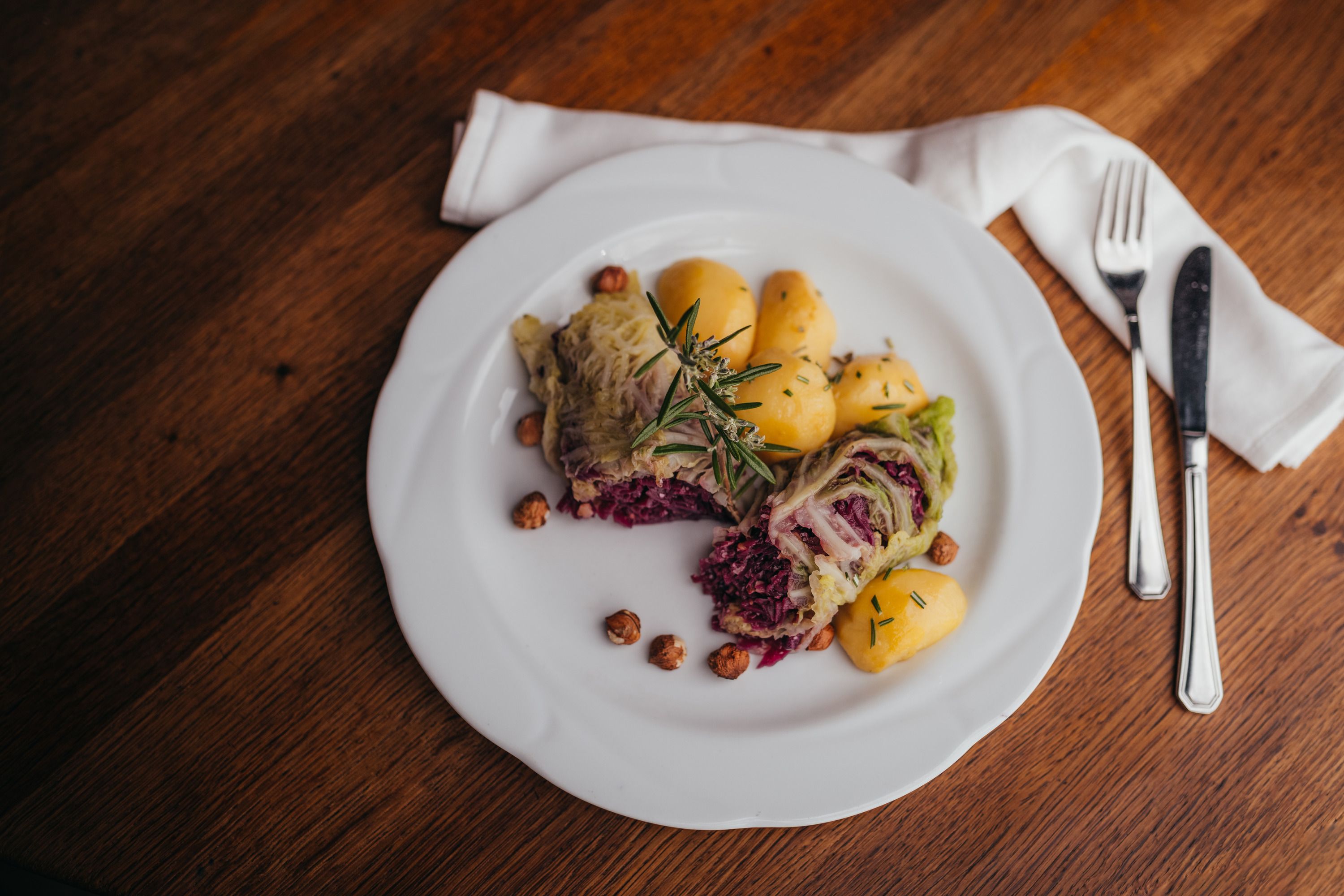 Na tanieri plnené kapustné listy, zemiaky a orechy, ozdobené rozmarínom.