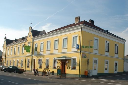 Žltá krčma na rohu ulice s niekoľkými oknami a vchodom.