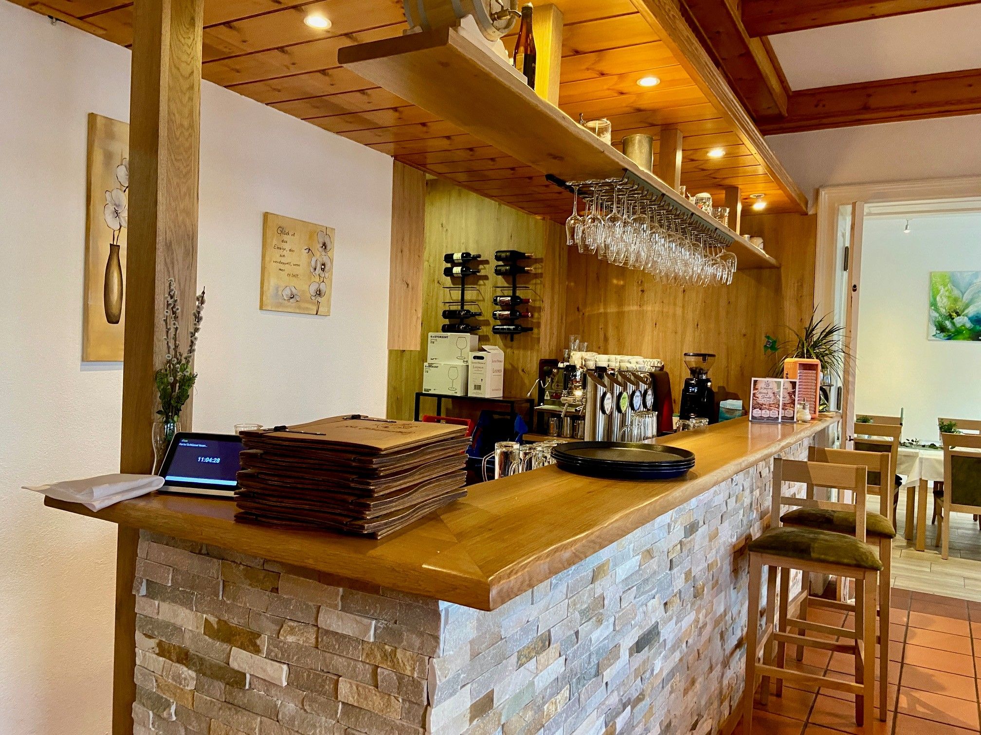 Útulný bar s dreveným pultom a stoličkami v hoteli Sankt Johannerhof.