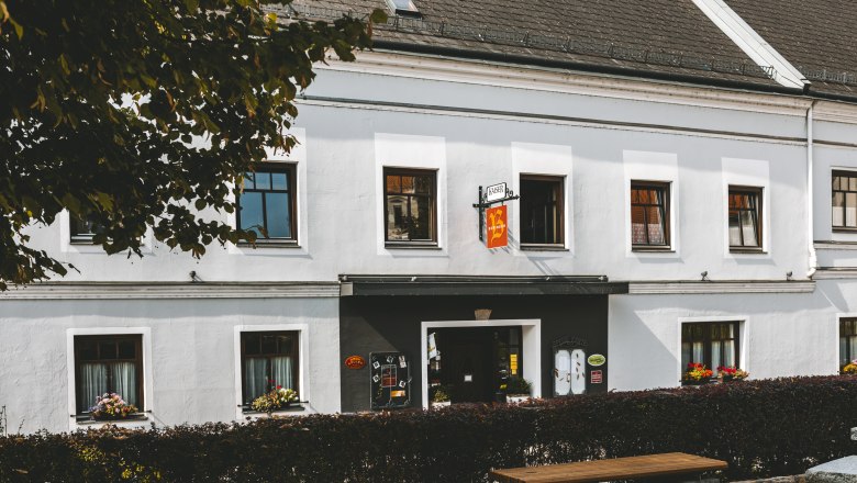 Tradičný hostinec v mestečku Mank s bielymi stenami a kvetinovými truhlicami na oknách.